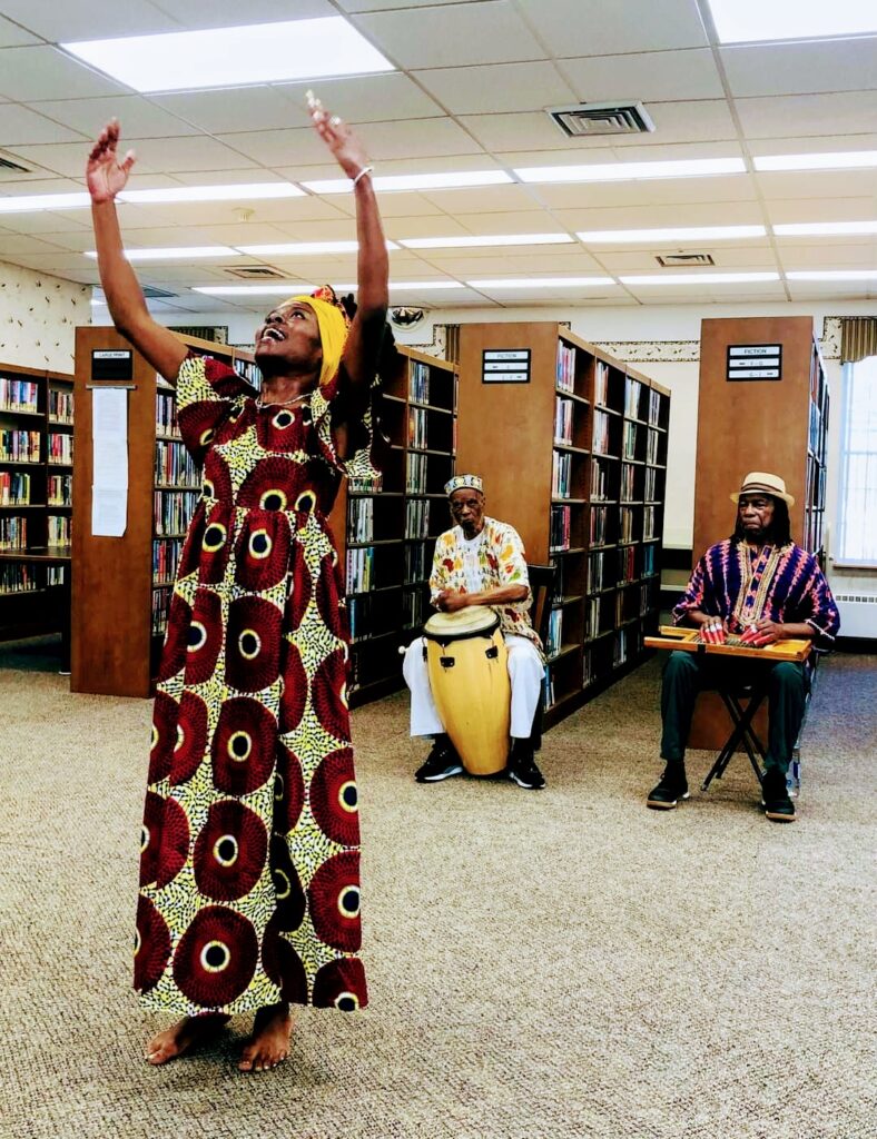 Shireen Dickson lifts hands in air during Fanga, and African American folk dance.